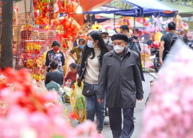 Des gens achètent des offrandes pour le culte du génie du Foyer. A cette occasion, les familles vietnamiennes préparent aussi de la nourriture, des fruits et des carpes pour faire une offrande à Ông Tao.