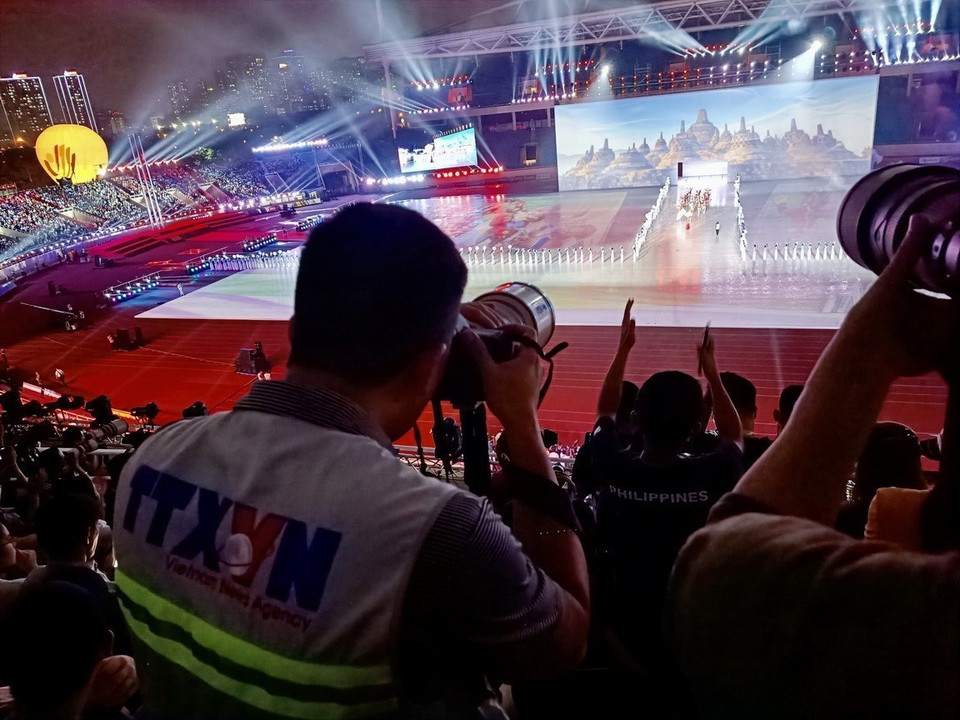 Des photojournalistes de l'Agence vietnamienne d'Information (VNA) à la cérémonie d'ouverture des SEA Games 31, tenue au stade national de My Dinh à Hanoï. Photo: VNA