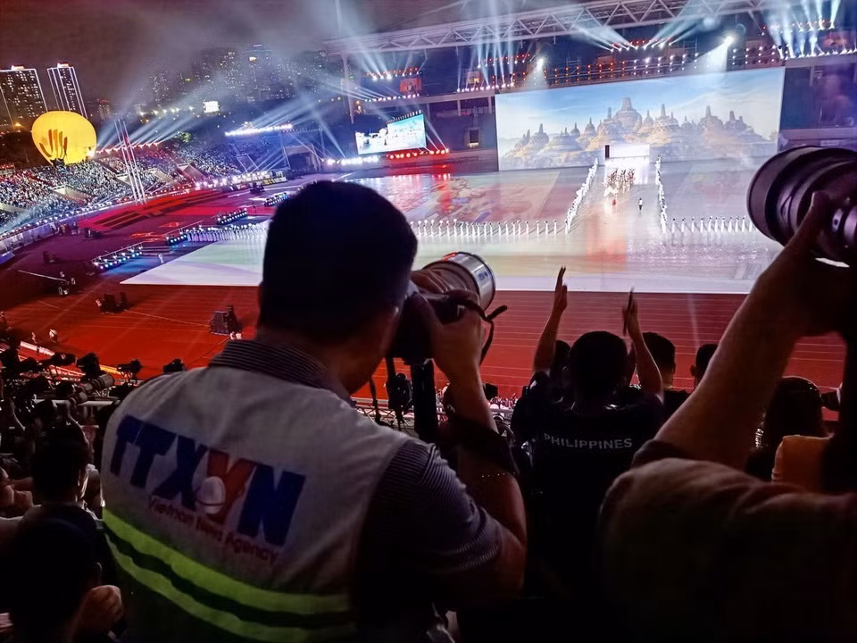 Des photojournalistes de l'Agence vietnamienne d'Information (VNA) à la cérémonie d'ouverture des SEA Games 31, tenue au stade national de My Dinh à Hanoï. Photo: VNA