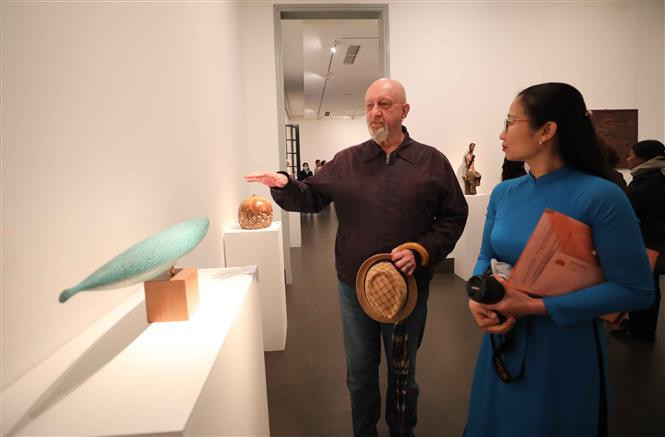  Les délégués contemplent des œuvres exposées. Photo : VNA