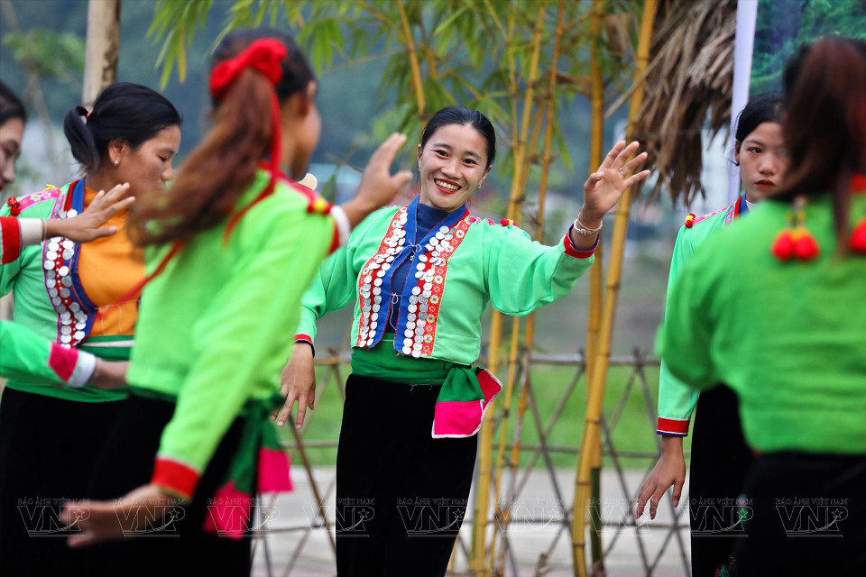 La tête est nue, les cheveux sont attachés en queue de cheval et les jambes sont enveloppées dans des jupes longues.