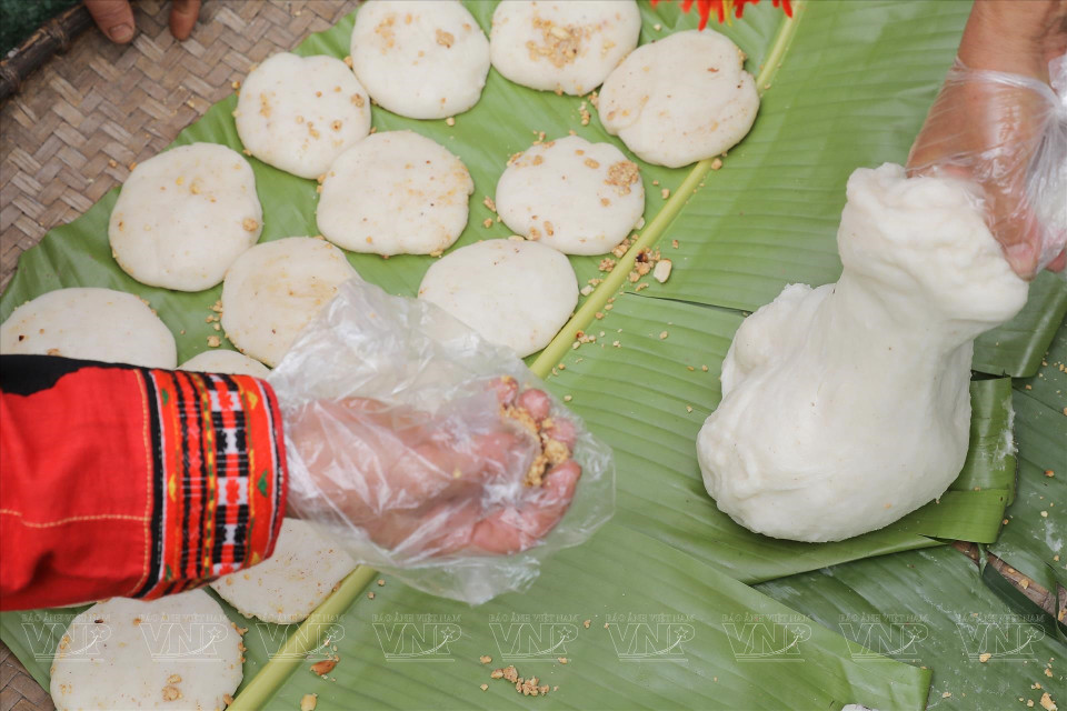 Les femmes façonnent le gâteau en cercle, puis l’enveloppent de feuilles de bananier chauffées au feu. Ensuite, elles pressent doucement le gâteau avec leurs mains pour créer une forme ronde comme la lune et le soleil.