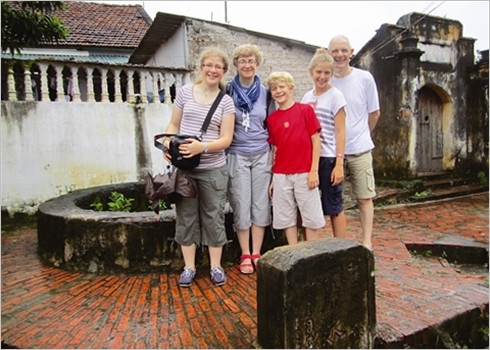 Des touristes à côté d’un puits à margelle presque centenaire.