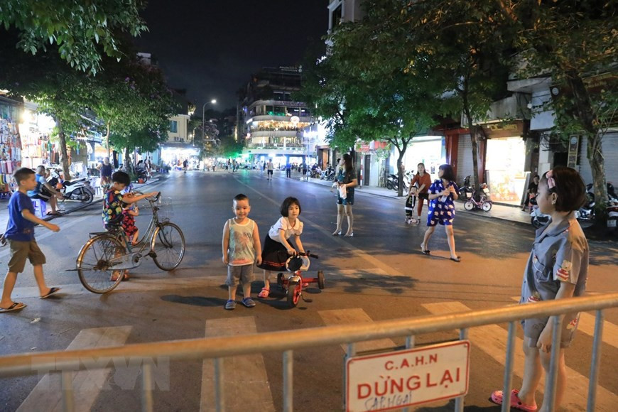 De jeunes enfants s'amusent dans la zone piétonne après plusieurs jours de confinement en raison de l'épidémie de COVID-19. Photo: VNA