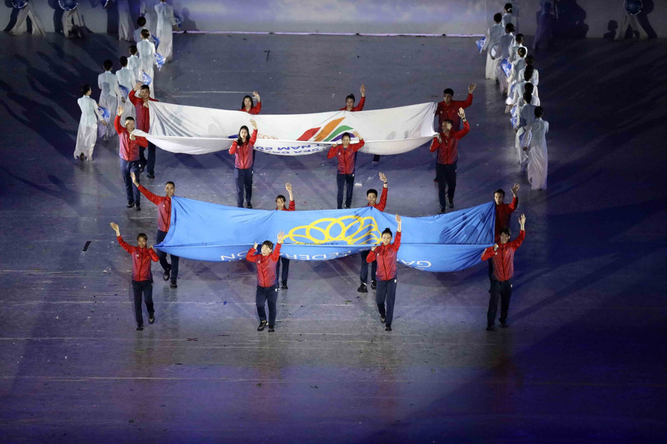  Des sportifs portent les drapeaux de la Fédération des sports d'Asie du Sud-Est et des SEA Games. Photo: VNA