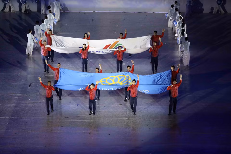  Des sportifs portent les drapeaux de la Fédération des sports d'Asie du Sud-Est et des SEA Games. Photo: VNA 