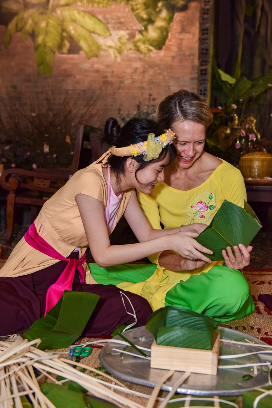 La confection du fameux « Banh chung » intéresse les amis internationaux. Photo : VNA