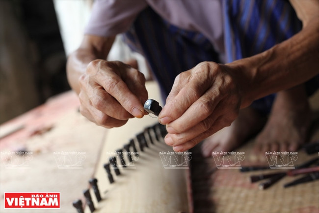  Dào Ngoc Soan travaille sur les clés d'un luth à 36 cordes. 