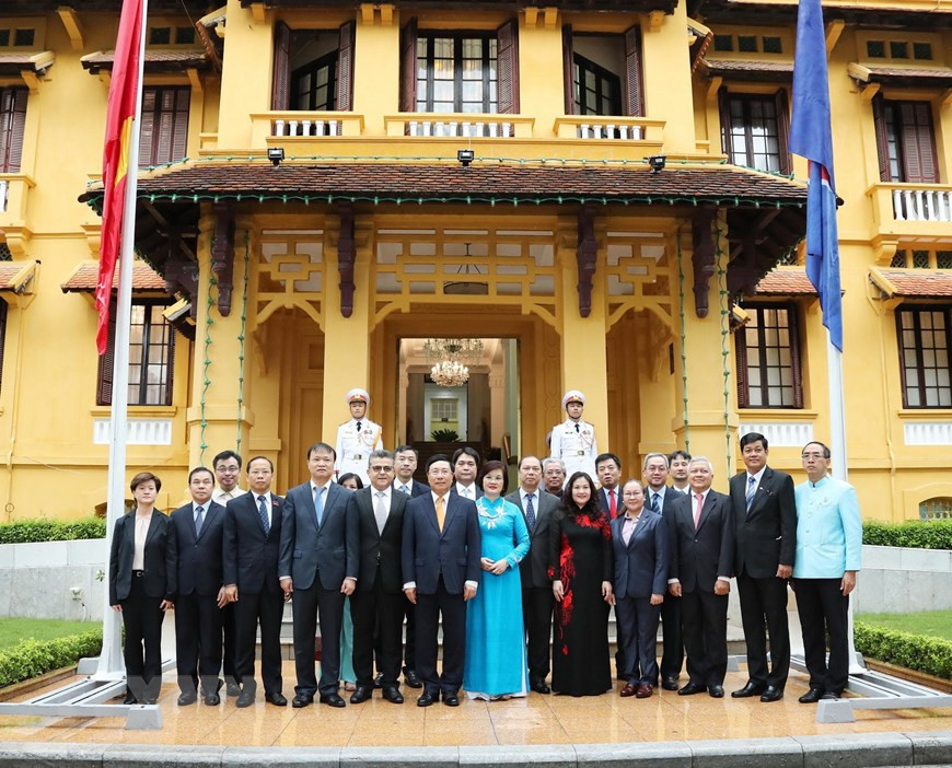 Le vice-Premier ministre Pham Binh Minh, ministre des Affaires étrangères et les délégués lors de la cérémonie de lever le drapeau de l'ASEAN à Hanoi. Photo: VNA