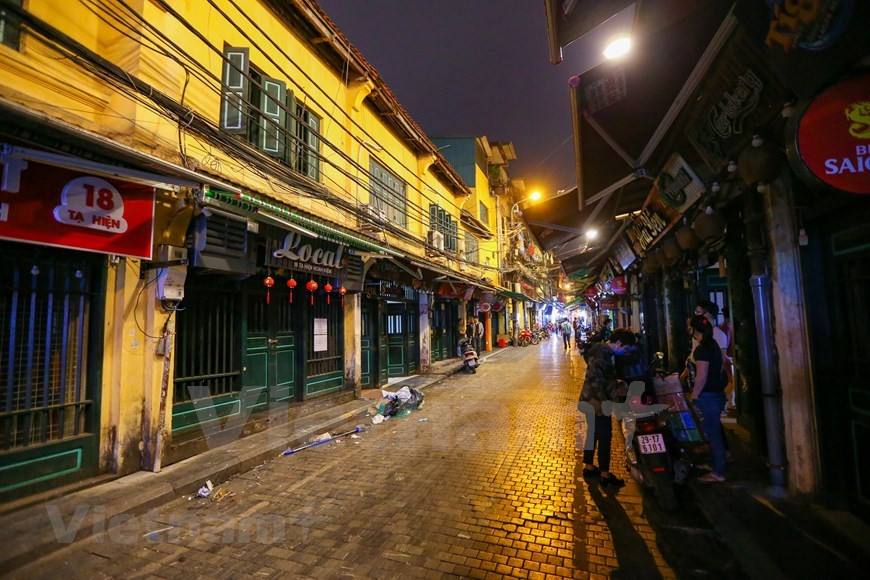  La rue Ta Hiên, qui ne dort jamais, est habituellement un des lieux prisés des touristes. Très difficile se l'imaginer aujourd'hui. Depuis de nombreuses années, les Hanoïens et les touristes aiment aller à la rue Ta Hiên car ils y trouvent l’ambiance agréable, les cuisines de très bon marché. Au-delà de la bière il y a diverses possibilités à essayer : thé au citron, thé glacé, café, … mais la bière reste toujours la boisson la plus choisie. Non seulement les Vietnamiens mais également de nombreux touristes internationaux viennent à Ta Hiên pour déguster de la bière sur le trottoir. Photo: VietnamPlus 