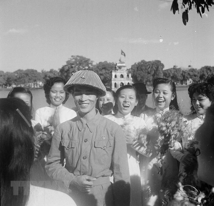 Des écolières hanoïennes accueillent le général de division Vuong Thua Vu, président du comité militaire de Hanoï qui était à la tête les troupes de victoire lors du jour de la libération de Hanoi.