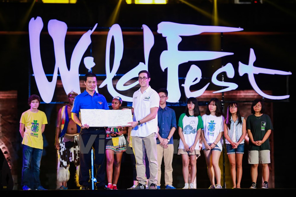 Vu Minh Ly, directeur du Centre national des volontaires de l'Union de la jeunesse communiste Ho Chi Minh reçoit un livre avec des signatures de nombreux jeunes du monde entier qui s'engagent à protéger le rhinocéros.