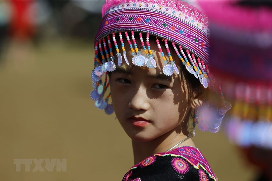 Une fille H'mong porte un chapeau traditionnel coloré pendant le festival 