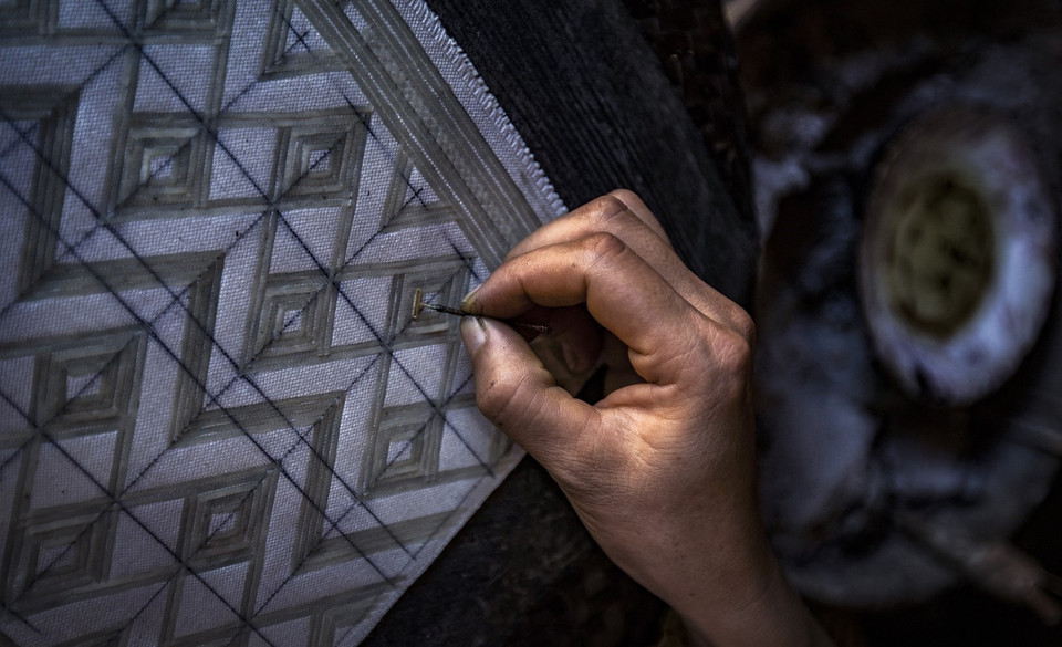 Les motifs ne devant pas être teints par l'indigo sont préservés par une dépôt de cire d'abeille (technique du batik). 