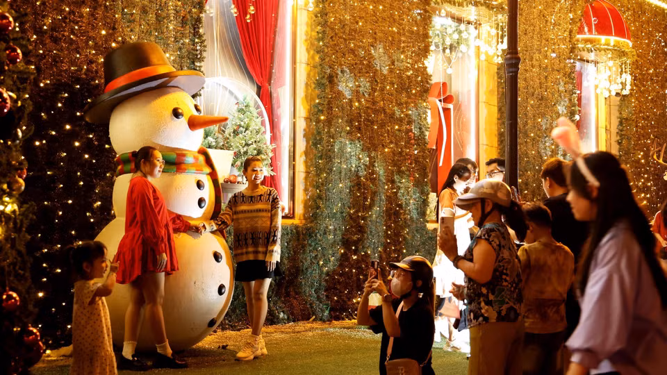 Des gens s’amusent et admirent la belle scène de Noël du Diamond Plaza, à Hô Chi Minh-Ville.