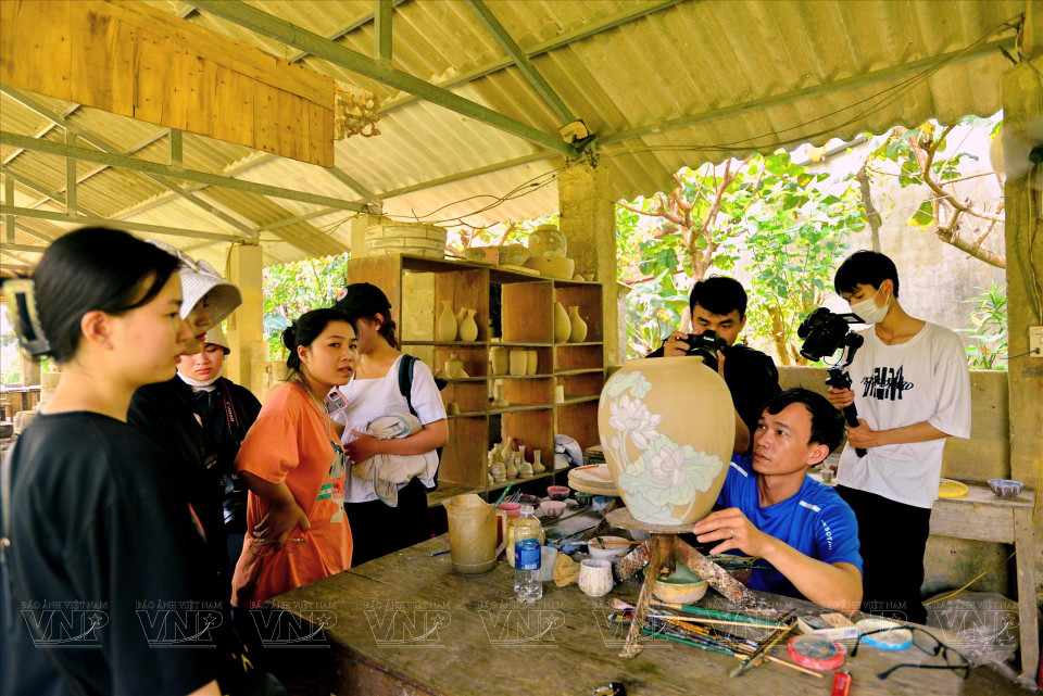 Des jeunes visitent et explorent le processus de fabrication de poterie à Phuoc Tich.