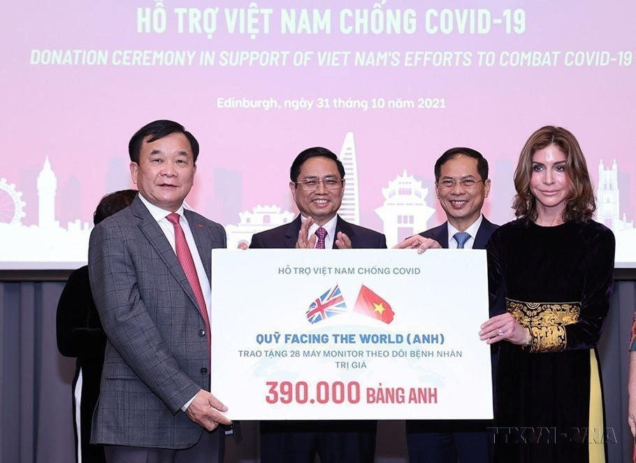 Le Premier ministre Pham Minh Chinh assiste à la cérémonie de remise de don pour soutenir le Vietnam dans sa lutte contre le COVID-19, lors de sa visite de travail au Royaume-Uni en 2021.