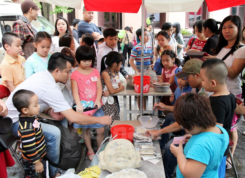 Des artisans donnent des matières premières aux enfants.