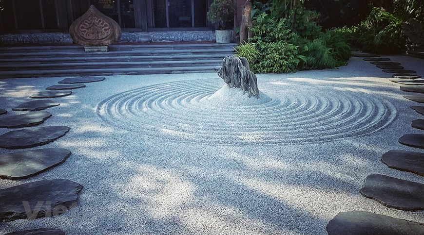 Face à la maison ancestrale, 12 cercles dessinés sur un fond de gravier représentent la vie humaine. Photo : VNA