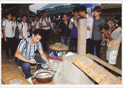 Un touriste étranger apprend à fabriquer une galette de riz.
