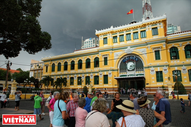 Touristes étrangers visitant la Poste Centrale de Saigon à côté de la Cathédrale.