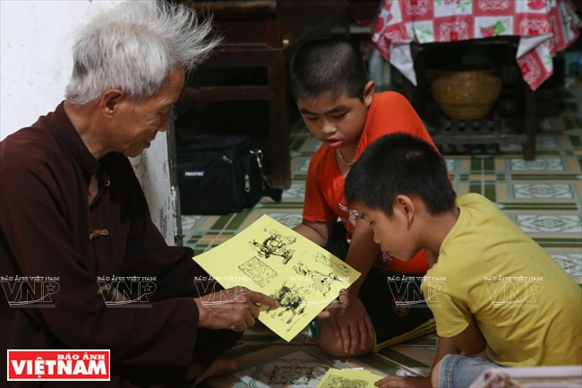 M.Quyên apprend aux enfants la signification des images qui se déplacent sur une lanterne tournante traditionnelle.