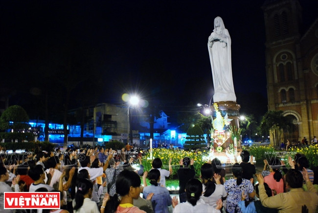 Les catholiques prient au pied de la statue de Notre-Dame de la Paix en face de l'église Notre-Dame de Saigon.