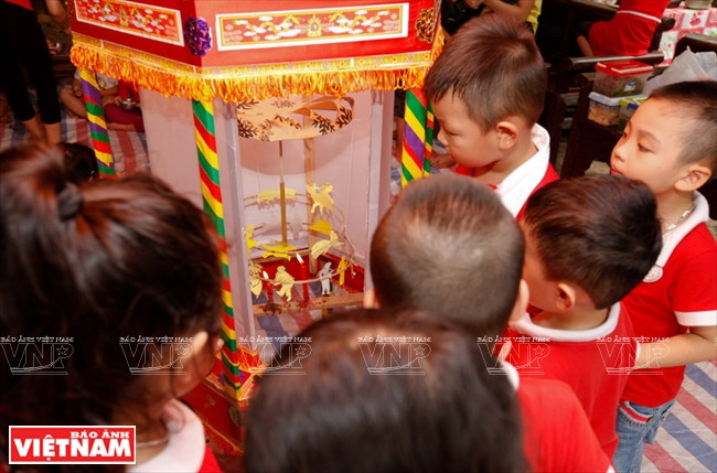 Les enfants découvrent une lanterne tournante, un jouet traditionnel de la fête de la mi-automne.