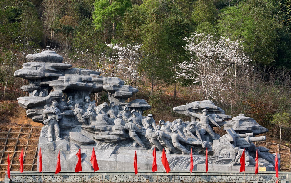 La bauhinie en pleine floraison dans l'ensemble des statues représentant des soldats tirant des pièces d'artillerie. 