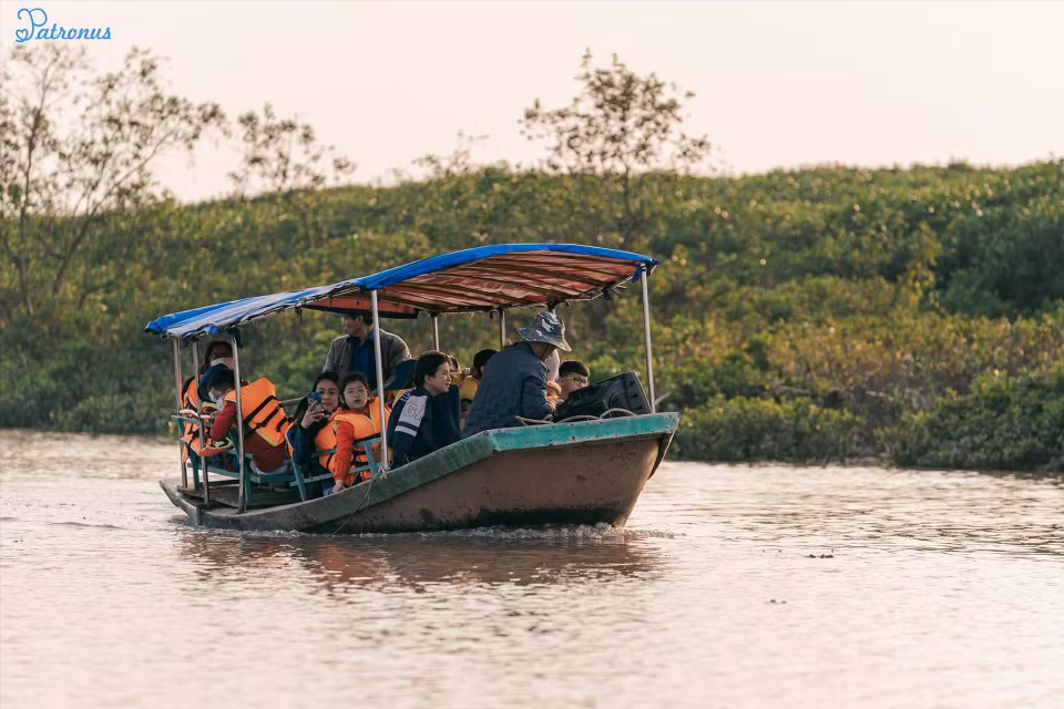 Les touristes font une promenade en bateau à travers la mangroves pour admirer le paysage.
