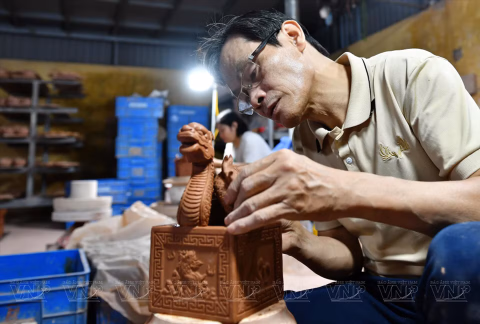 Ces jours-ci, Pham Viet Khoa et ses collègues potiers sont occupés à perfectionner des produits portant le symbole de la mascotte du dragon, commandés par un établissement commercial. 