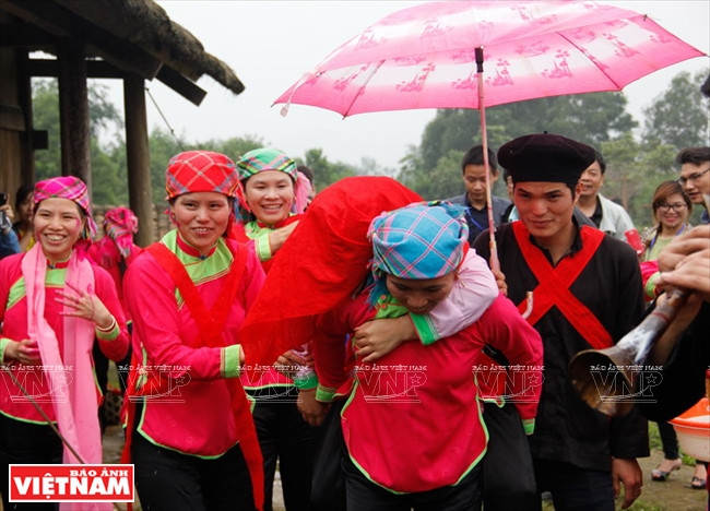 Une femme forte porte la mariée sur son dos pour l’emmener chez la famille du marié.