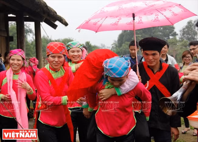 Une femme forte porte la mariée sur son dos pour l’emmener chez la famille du marié.