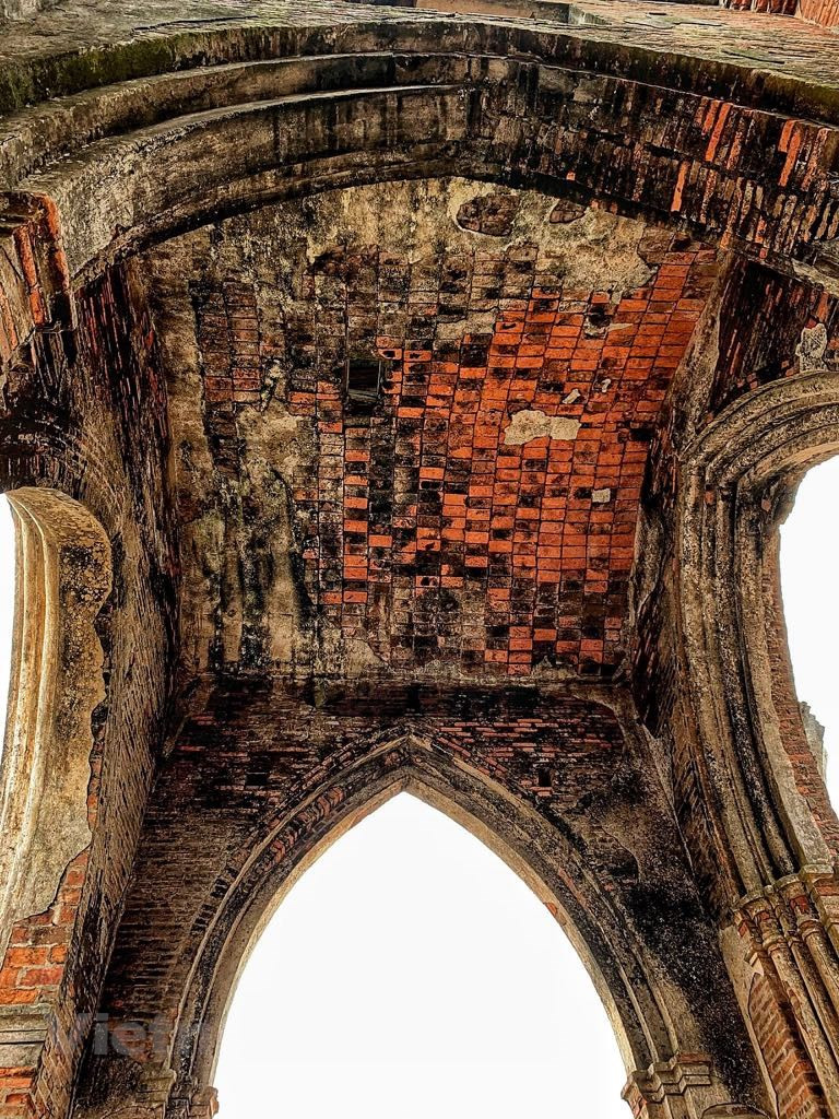  Le soleil cuivré de l'aube crée des teintes uniques sur l'église ruinée qui s’harmonisent bien avec l'océan tout proche. Photo: Vietnamplus