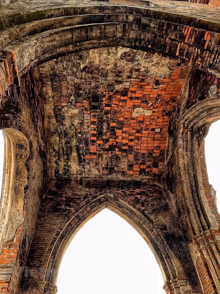  Le soleil cuivré de l'aube crée des teintes uniques sur l'église ruinée qui s’harmonisent bien avec l'océan tout proche. Photo: Vietnamplus 