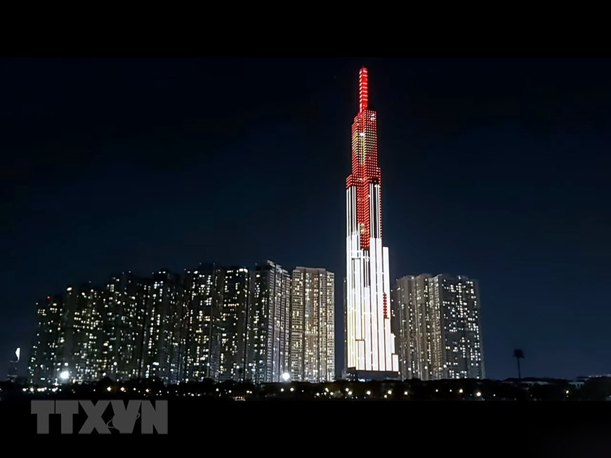  Le gratte-ciel Landmark 81, dans la rue Nguyen Huu Canh, arrondissement de Binh Thanh, avec le message ''Allumer le cœur - répandre l'amour, éradiquer le COVID-19''. Photo: VNA
