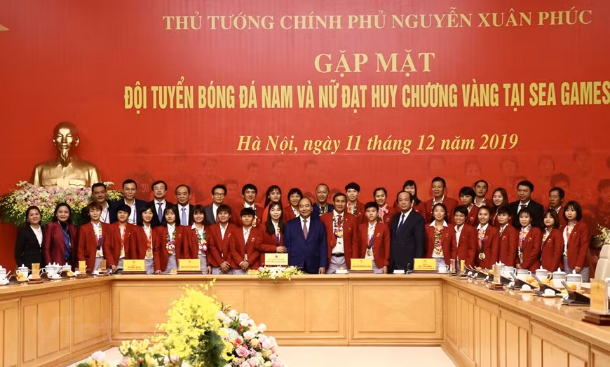 Le Premier ministre Nguyen Xuan Phuc prend un photo avec l'équipe de football féminin.