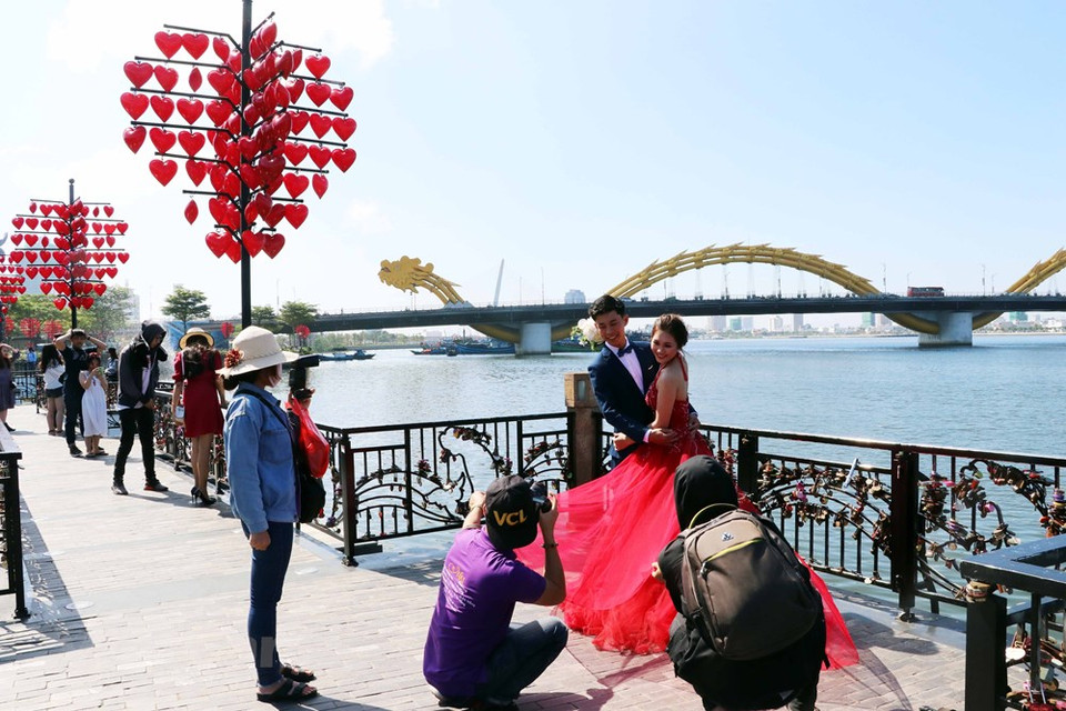 Un couple prend les photos de mariage sur le pont.