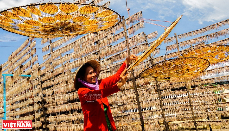 Des pêcheurs font sécher des poissons. 