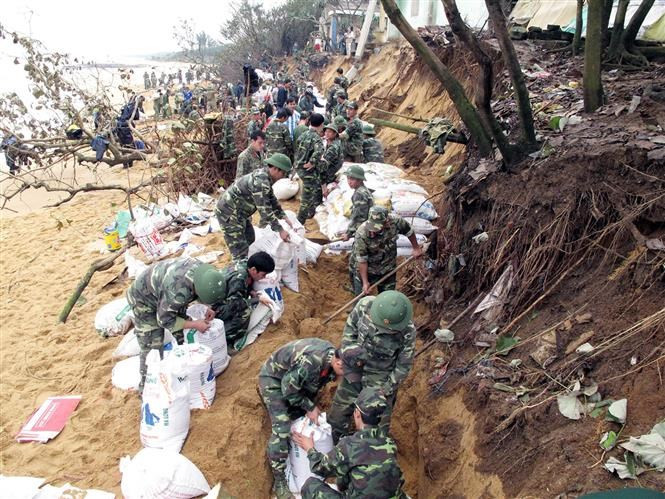 Des soldats participent à la construction de digues pour empêcher les vagues.