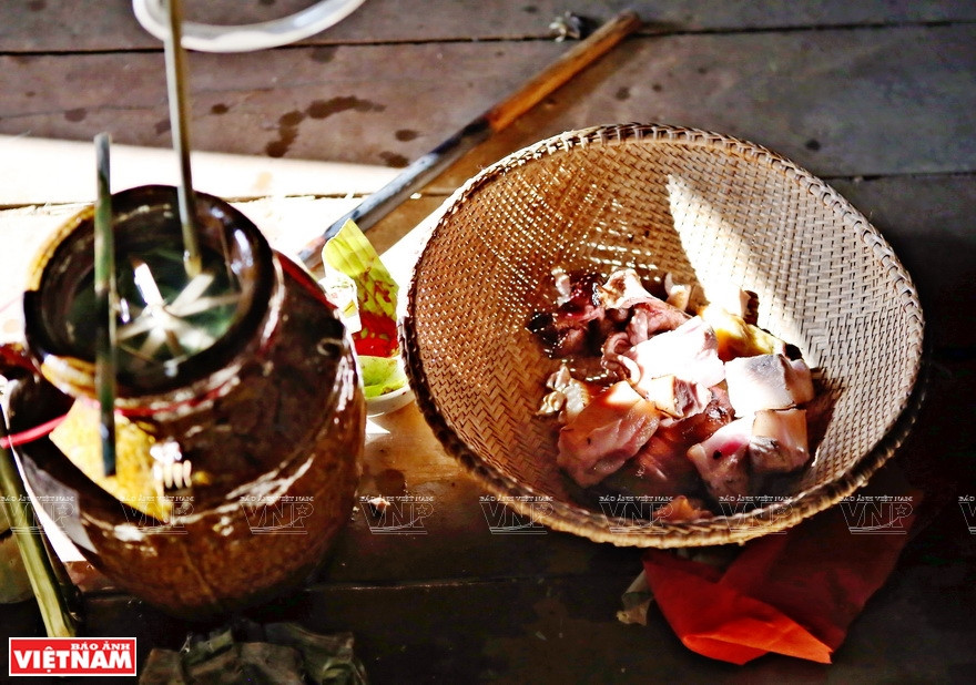 La jarre d'alcool à siroter avec un chalumeau de bambou (ruou cân) et la viande.