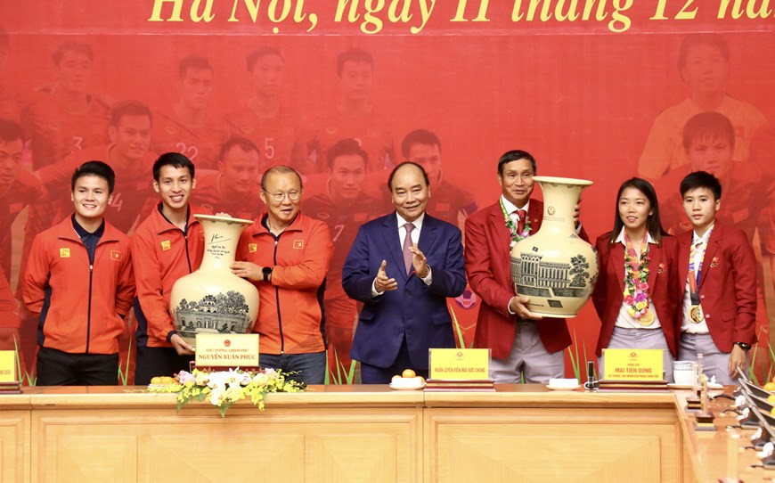 Le Premier ministre Nguyen Xuan Phuc offre deux vases en céramique aux équipes masculine et féminine.