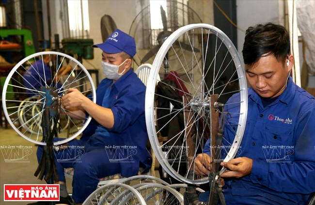 Des ouvriers de la compagnie Thong Nhat examinent des jantes.