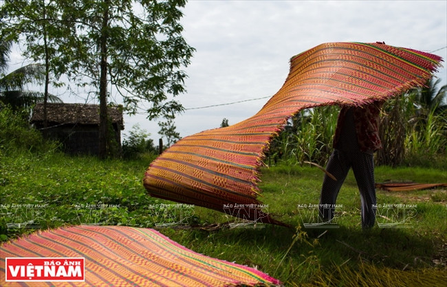 Une natte est séchée au soleil après son tissage.