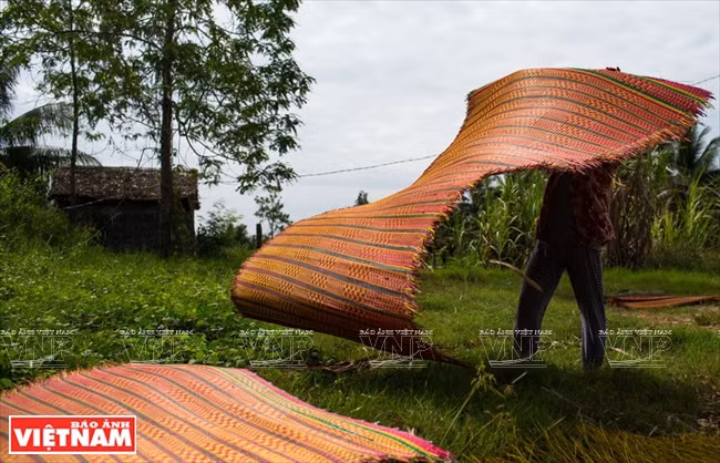 Une natte est séchée au soleil après son tissage.