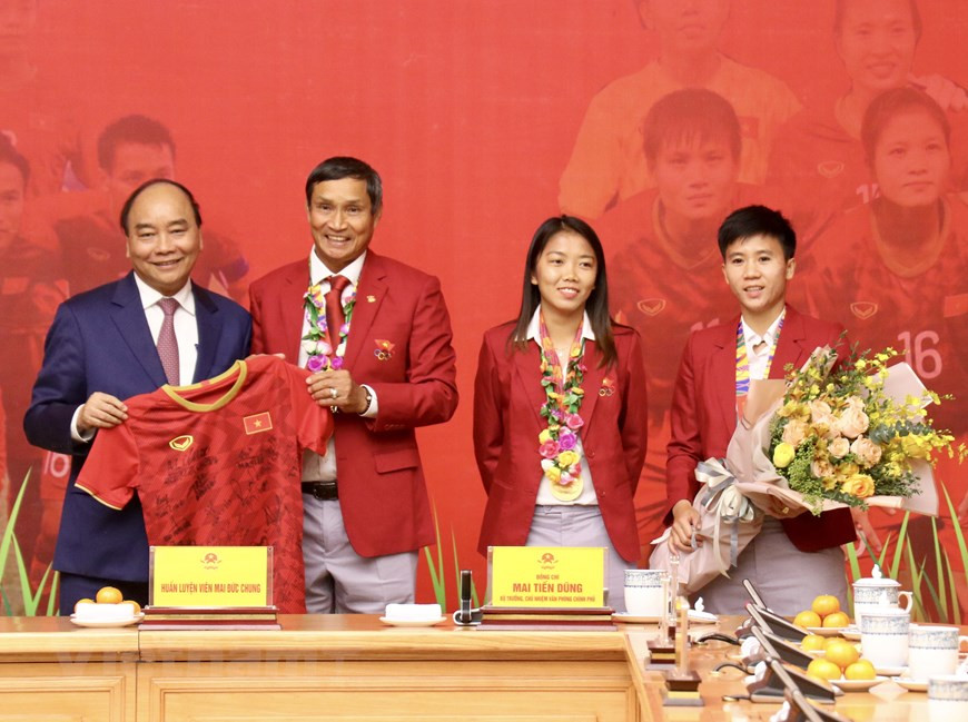 L'équipe de football féminin offre également un maillot de foot signé par les footballeurs de la sélection nationale vietnamienne au Premier ministre.