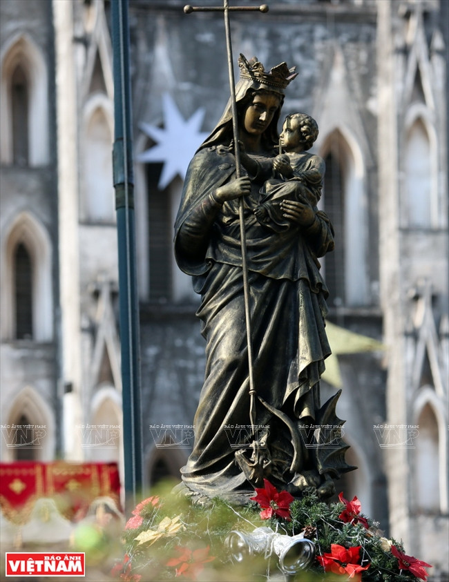 Une statue de la Vierge Marie en métal trône sur le parvis de l’église.