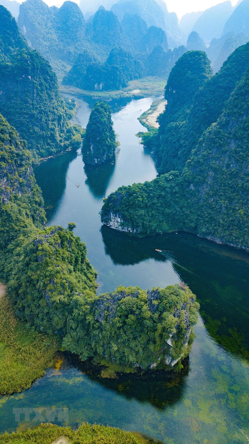 Trang An est un spectaculaire paysage de pitons karstiques sillonné de vallées, pour certaines immergées, et encadré de falaises abruptes.