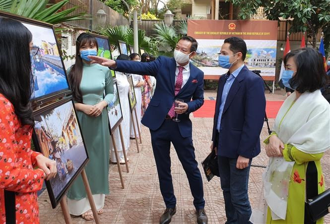L'ambassadeur vietnamien Tran Thanh Cong (au milieu) présente des photos sur la nature vietnamienne. 