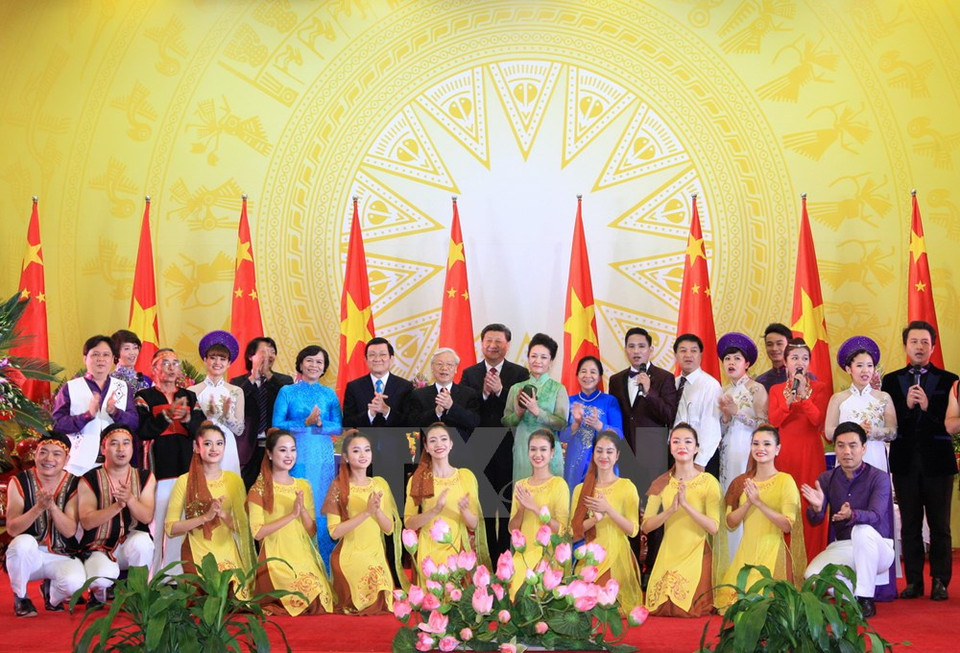 Le secrétaire général du PCV Nguyen Phu Trong, le président Truong Tan Sang et le dirigeant chinois Xi Jinping, accompagnés de leurs épouses, prennent une photo avec les artistes. 